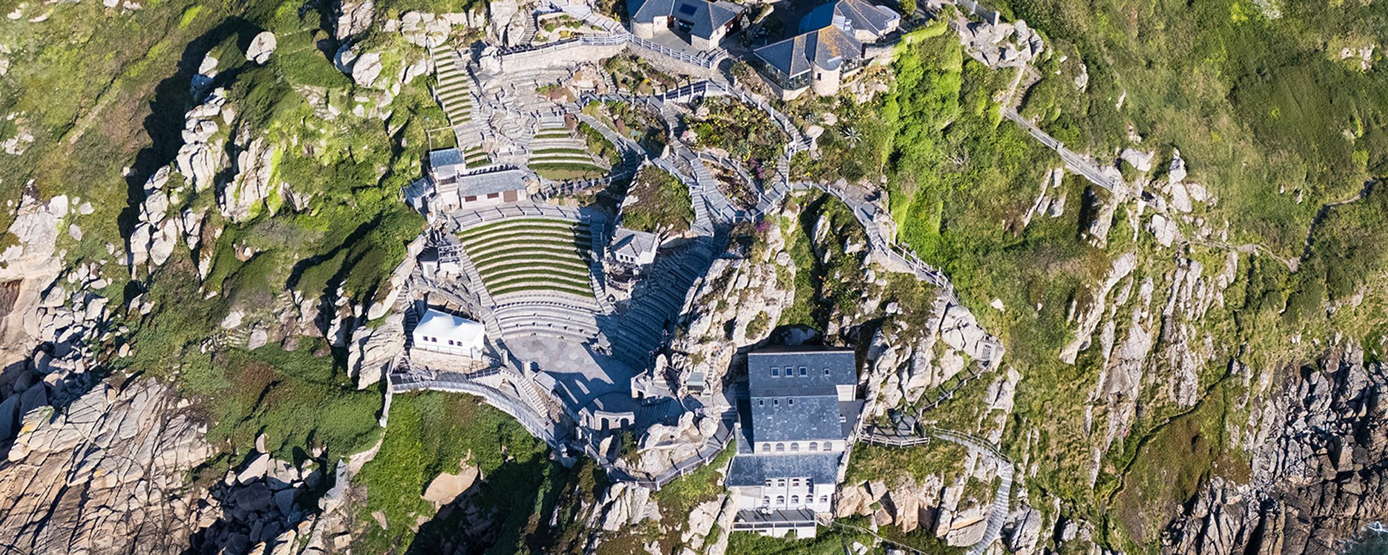 Wide aerial image of the Minack and surrounding cliffs