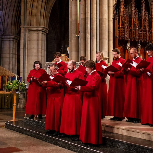 Truro Cathedral Choir singing beside a large crib