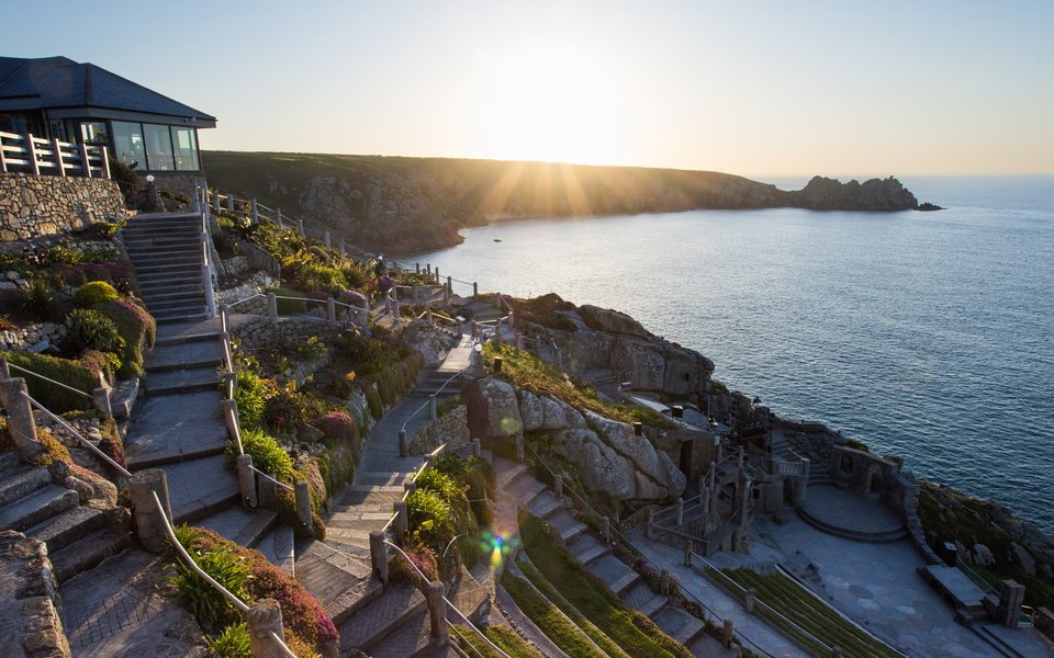 Wide shot of the Minack and Porthcurno bay at dawn