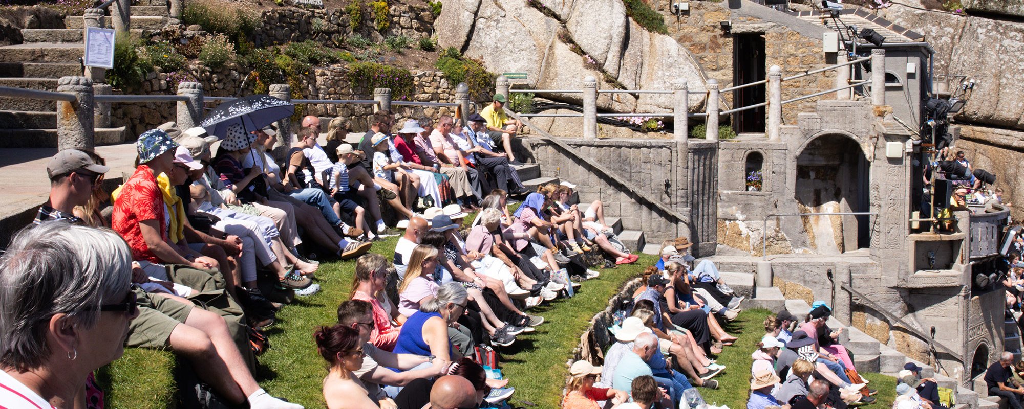 Audience watching a performance at the Minack on a sunny afternoon