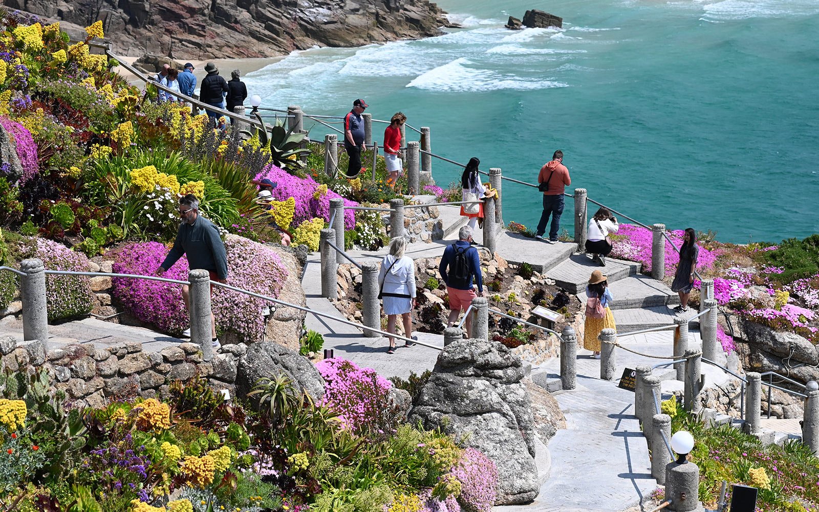 Minack garden with sea in background and people enjoying the scenery